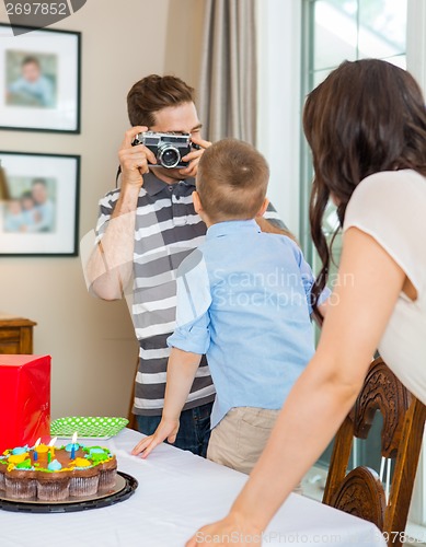 Image of Father Taking Picture Of Birthday Boy And Woman