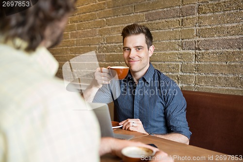 Image of Smiling Man Having Coffee At Coffee Shop