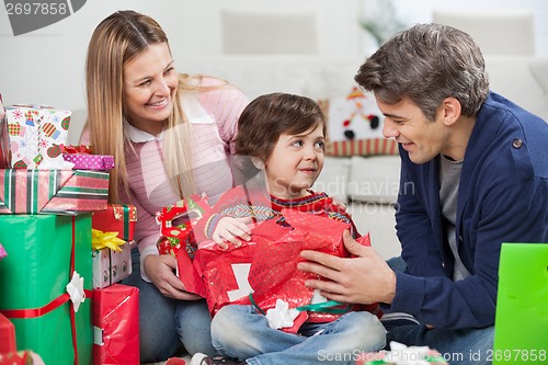 Image of Parents With Son Opening Christmas Gift