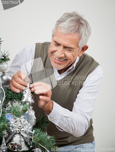Image of Senior Man Decorating Christmas Tree