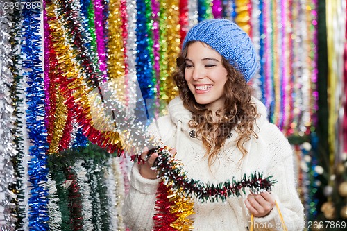 Image of Young Woman Choosing Tinsels At Store