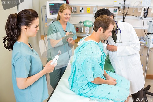 Image of Doctor And Nurses Examining Patient