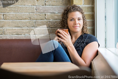 Image of Woman With Coffee Mug Sitting In Cafeteria