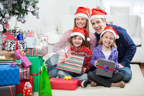 Image of Family Sitting By Christmas Gifts