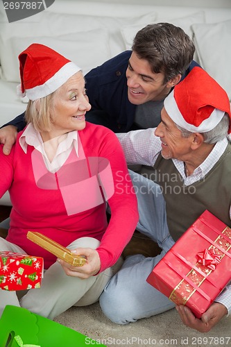 Image of Son With Parents Holding Christmas Presents