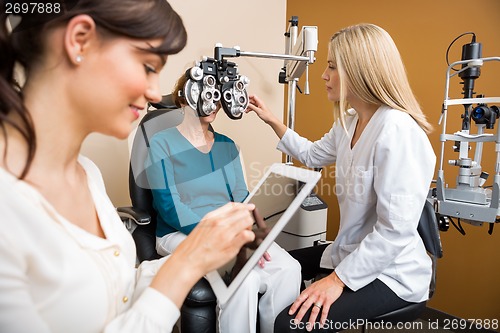 Image of Optometrists Examining Senior Woman In Store