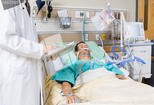 Image of Doctor With Clipboard Examining Patient's Medical Report