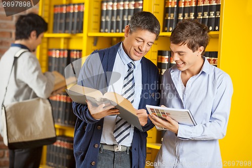 Image of Librarian Assisting Student In University Library