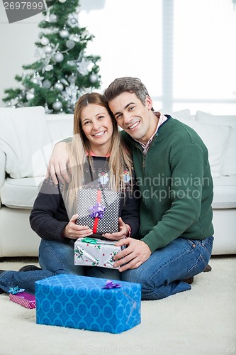 Image of Loving Couple With Christmas Gifts At Home