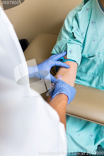 Image of Male Doctor Drawing Blood From Patient's Arm