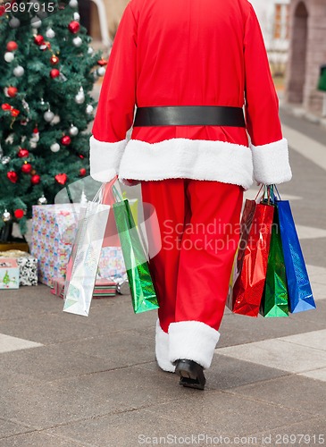 Image of Santa Claus With Shopping Bags Walking In Courtyard