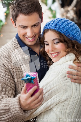 Image of Romantic Couple Looking At Gift Box In Store
