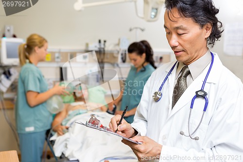 Image of Doctor Writing Notes in Emergency