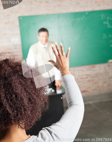 Image of College Student Raising Hand To Answer In Classroom