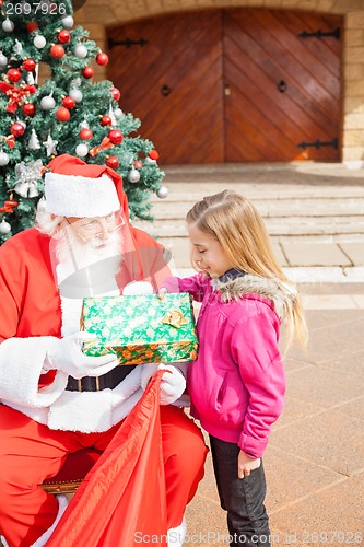 Image of Girl Receiving Present From Santa Claus