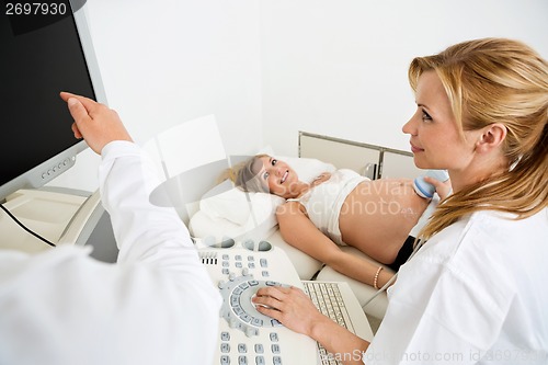 Image of Obstetricians Scanning Pregnant Woman's Belly