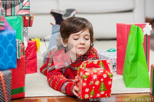 Image of Boy With Christmas Present Lying On Floor