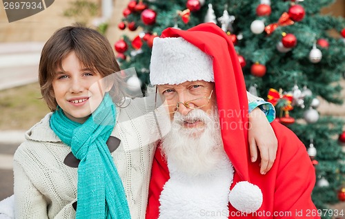 Image of Boy With Arm Around Santa Claus Outdoors