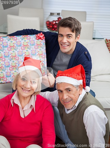 Image of Family With Christmas Present Smiling At Home