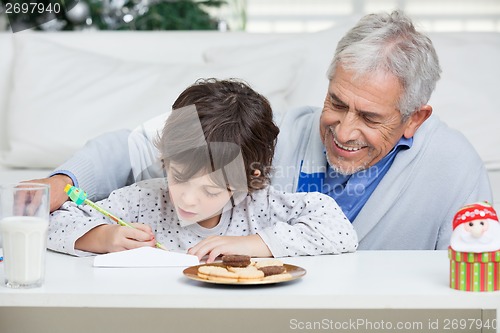 Image of Grandfather Assisting Boy In Writing Letter To Santa Claus