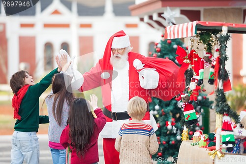 Image of Children Giving High Five To Santa Claus