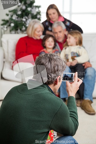 Image of Man Photographing Family Through Smartphone