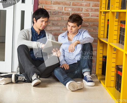 Image of Male Students Using Digital Tablet While Sitting In Library