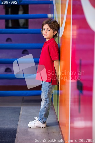 Image of Unhappy Boy Standing Against Wall