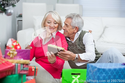 Image of Senior Man Giving Christmas Gift To Woman