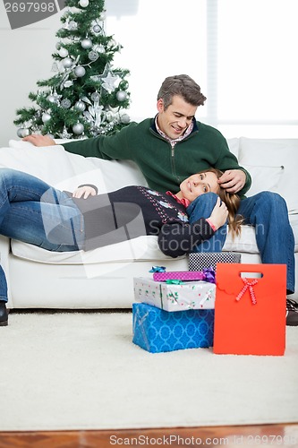 Image of Couple With Christmas Presents Relaxing On Sofa