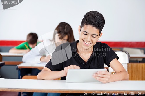 Image of Teenage Schoolboy Using Digital Tablet At Desk