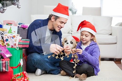 Image of Girl And Father Holding Christmas Ornaments