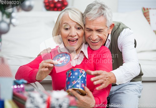 Image of Surprised Senior Woman With Man Looking At Christmas Gift