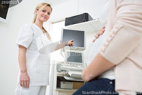 Image of Gynecologist Showing Ultrasound Scan To Pregnant Woman