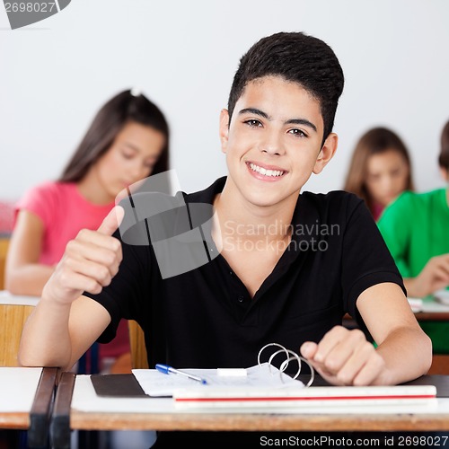 Image of Teenage Schoolboy Gesturing Thumbs Up In Classroom