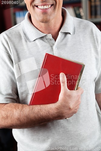 Image of Male Librarian Holding Book In Library