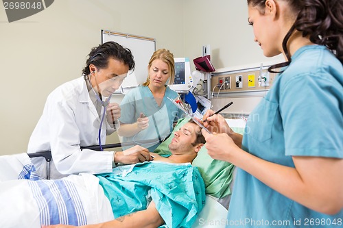 Image of Doctor And Nurses Examining Patient
