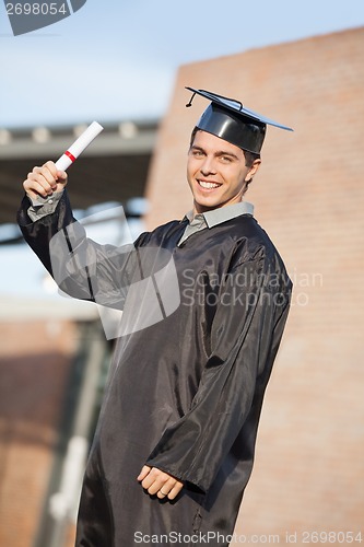 Image of Male Student Holding Diploma On Graduation Day At Campus