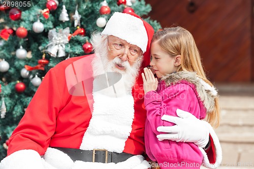 Image of Girl Telling Wish In Santa Claus's Ear