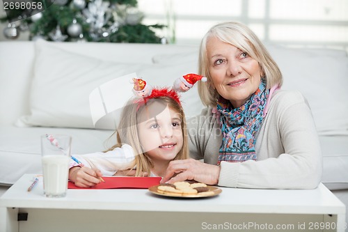 Image of Girl And Grandmother With Cardpaper At Home