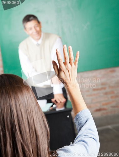 Image of College Student Raising Hand To Answer In Classroom