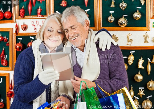 Image of Happy Couple Using Digital Tablet At Christmas Store