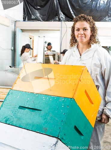 Image of Female Beekeeper Holding Trolley Of Stacked Honeycomb Crates