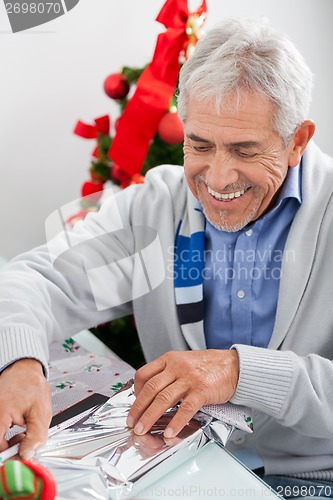 Image of Man Wrapping Christmas Gift