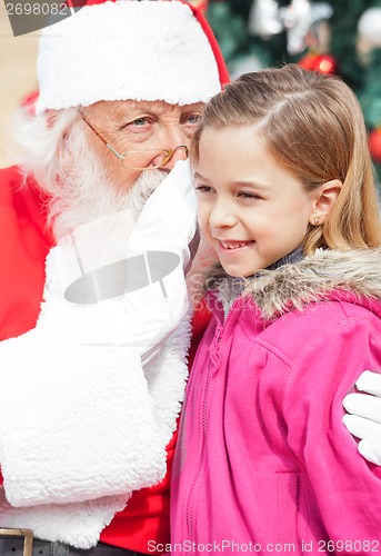 Image of Santa Claus Whispering In Girl's Ear