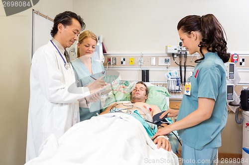 Image of Medical Team Examining Patient In Hospital