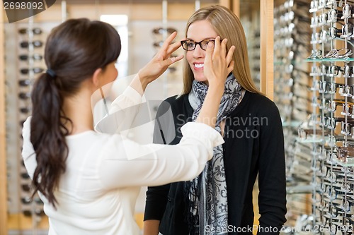 Image of Salesgirl Assisting Customer To In Wearing Glasses