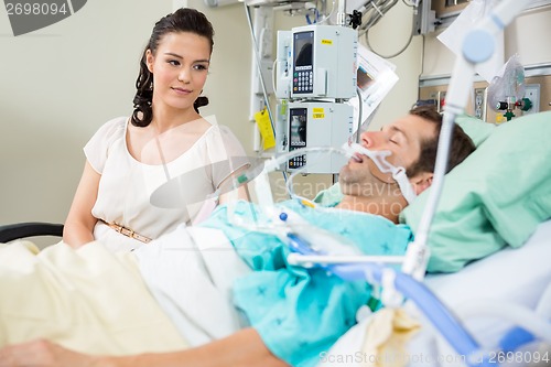 Image of Woman Looking At Patient Resting On Bed