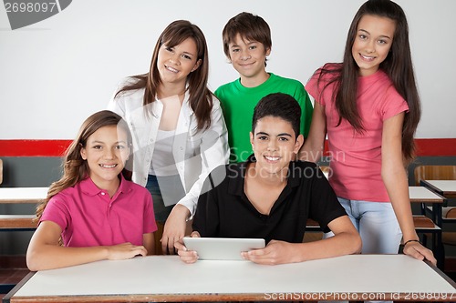 Image of Portrait Of Teenage Students Using Tablet At Desk