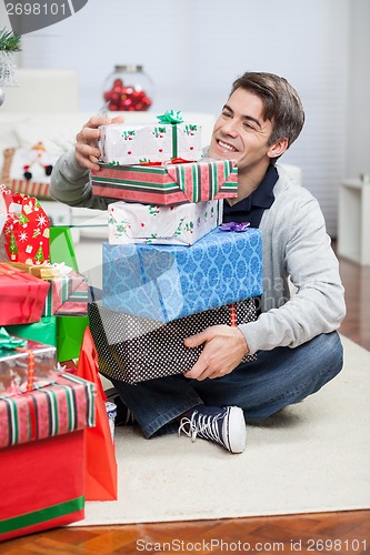 Image of Smiling Man With Stack Of Christmas Gifts